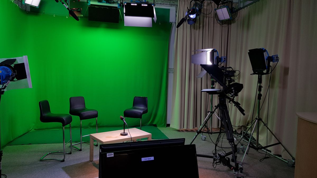 TV-Studio: 3 Stühle stehen vor einem Greenscreen.